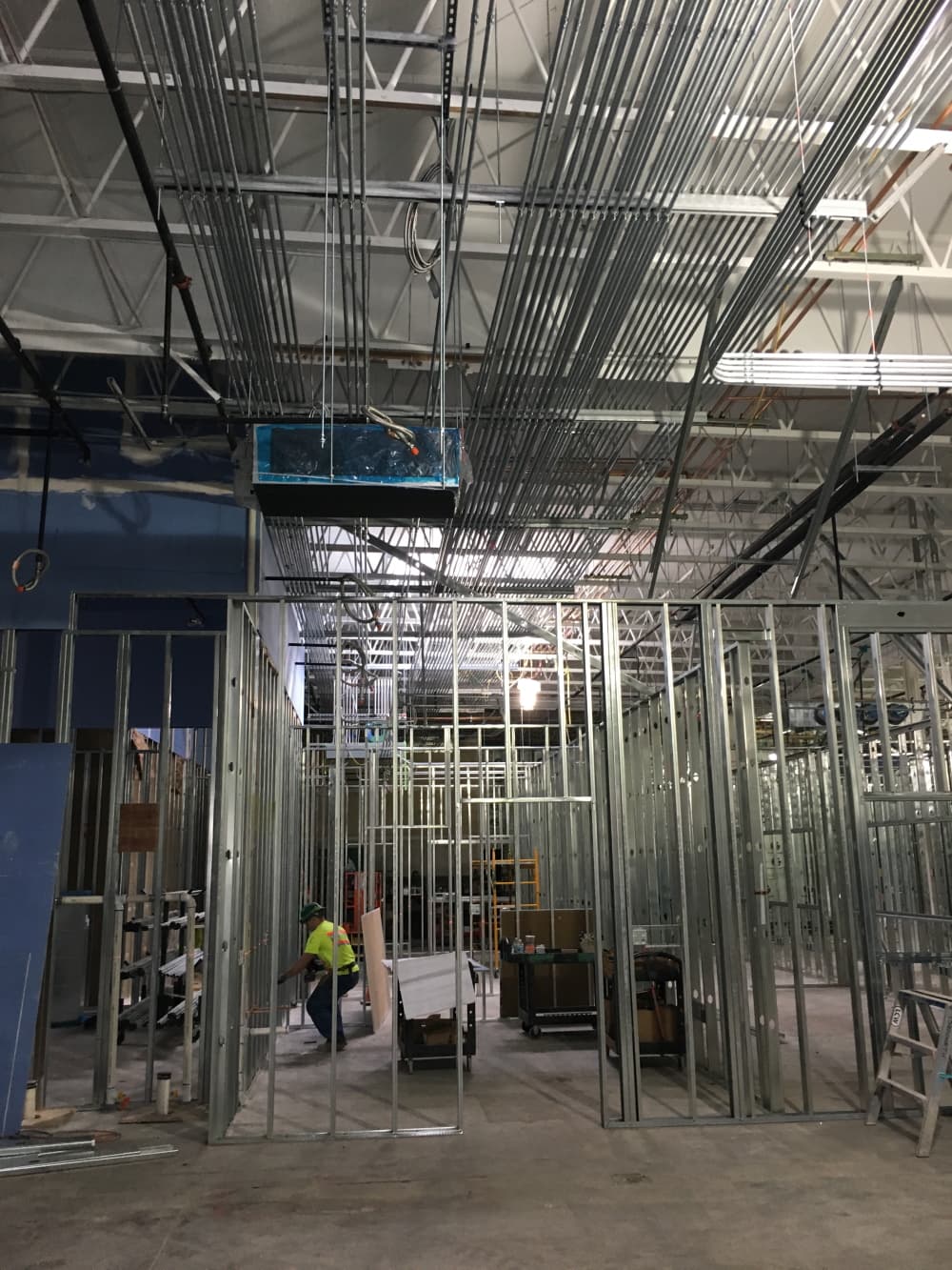H&M Electric electrician installing overhead conduit during a commercial build-out