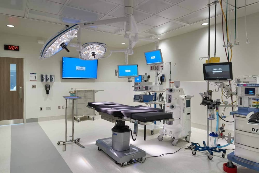 Electrical rough-in and overhead service booms inside a hospital operating room during construction